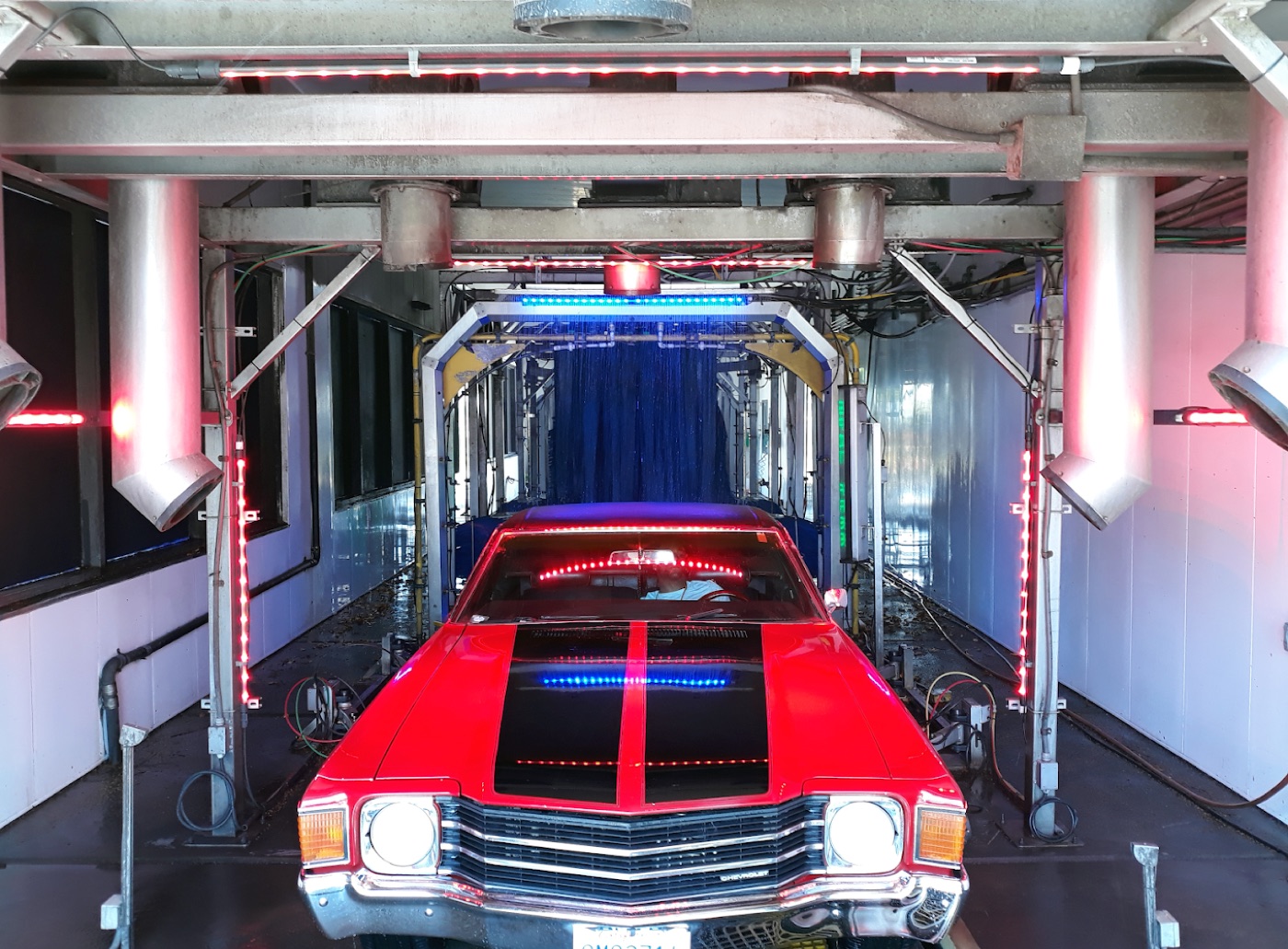 Classic red car inside the Bubba's Express Car Wash tunnel