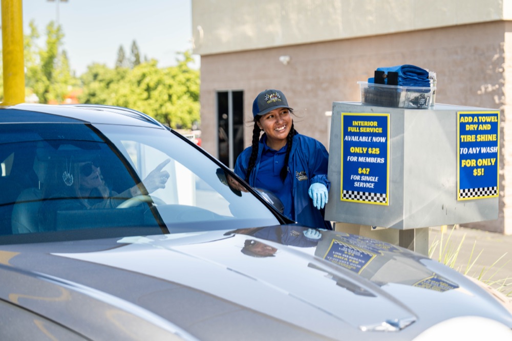 Bubba's team member at the pay station with full service pricing signage