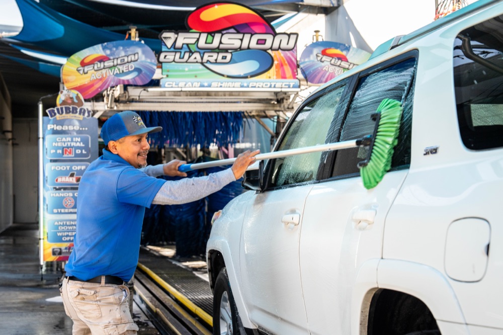 Team member scrubbing a windshield during hand prep at Bubba's