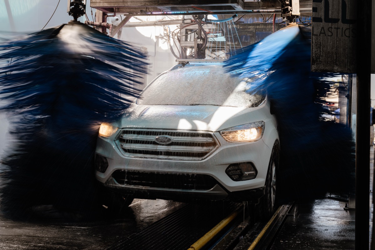 Vehicle being washed with blue brushes inside the Bubba's Express Car Wash tunnel