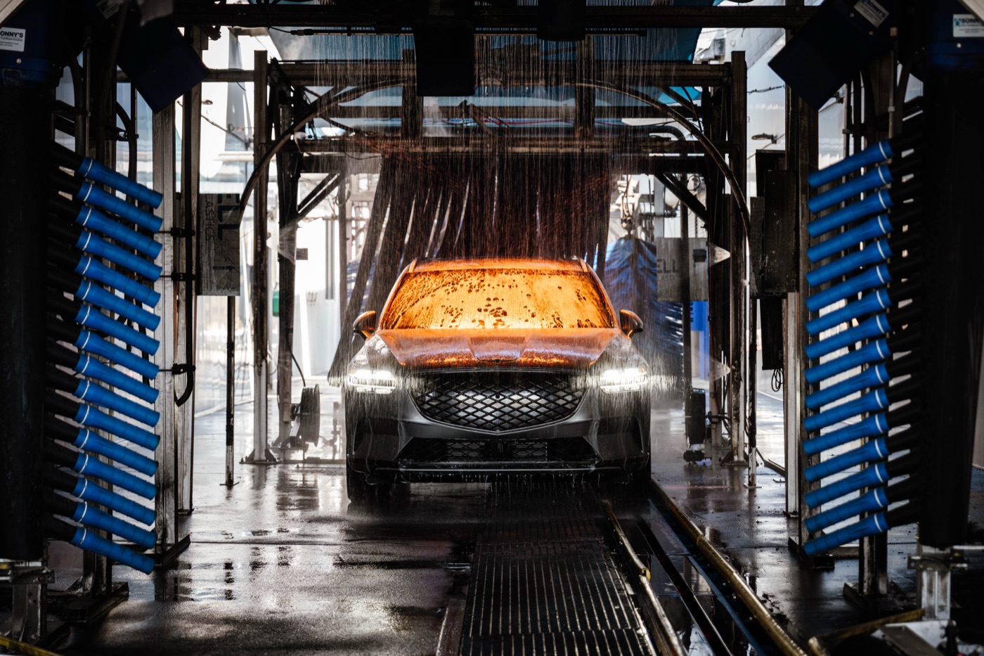 Car bathed in orange light inside the Bubba's wash tunnel